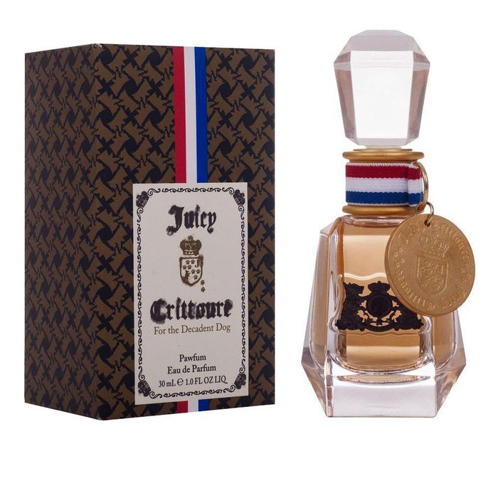 A glass perfume bottle is positioned beside an ornate box. The bottle is filled with a golden liquid, labeled 