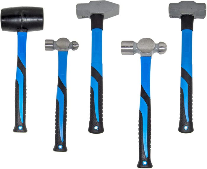 Five hammers with blue and black handles are arranged together, showcasing different types: a rubber mallet, ball peen, and two others, on a neutral background.