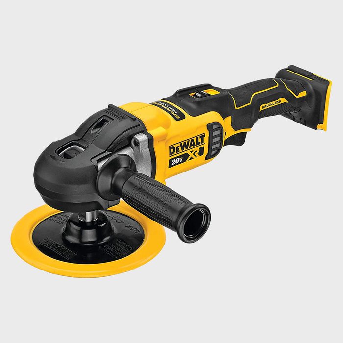 A yellow and black electric polisher rests on a surface, showcasing its circular pad and side handle, designed for surface finishing in various settings.