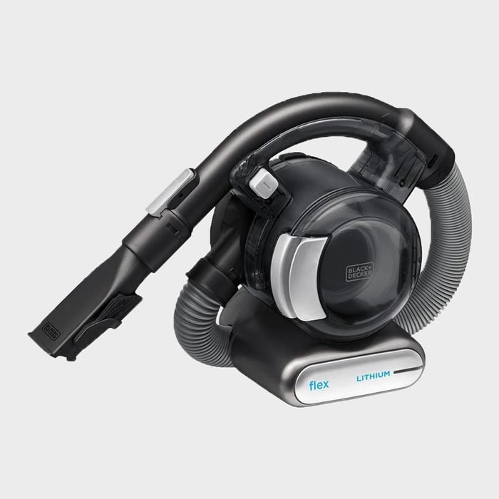 A compact, handheld vacuum cleaner is designed for easy cleaning, featuring a flexible hose and a transparent dust container, set against a neutral background.