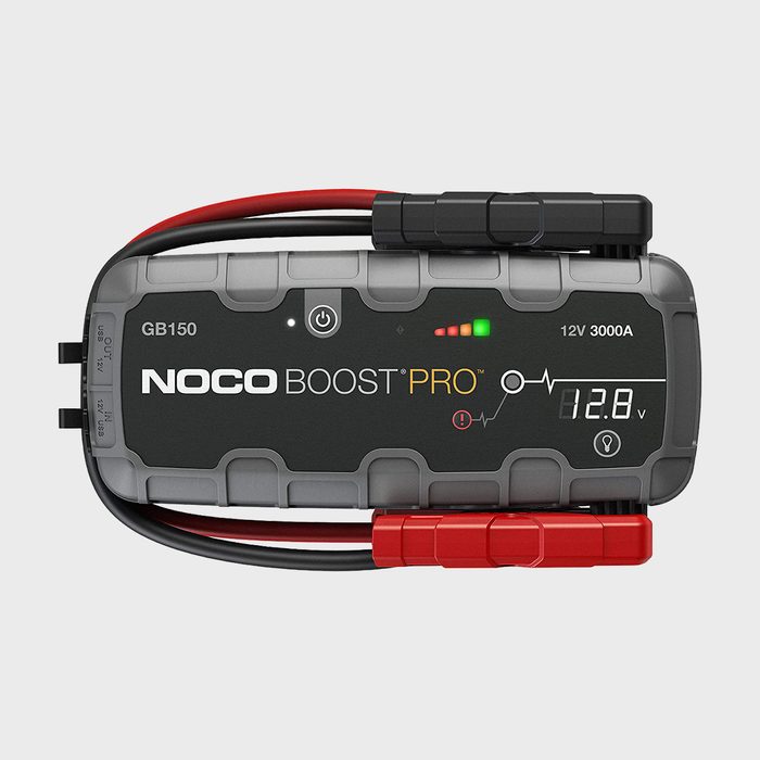 A portable jump starter displays a digital voltage reading of 12.8V, with red and black cables attached, against a neutral background.