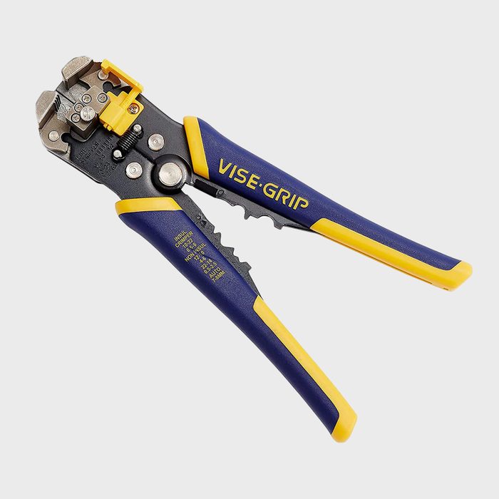 A pair of wire strippers grips and holds wires, featuring a metallic cutting edge and textured rubber handles, designed for electrical work.