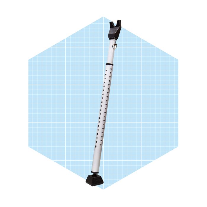 A long, white pole with a black grip and base stands upright, featuring holes along its length, set against a light blue grid background.